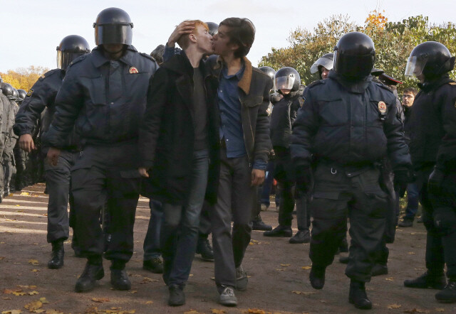 2013년 10월12일 미국 세인트피터즈버그에서 열린 동성애자 권리 시위에서 경찰에 잡힌 동성애자 인권운동가들이 키스를 하고 있다. REUTERS