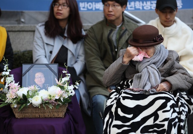 The weekly Wednesday protests calling for the resolution of the comfort women issue were held again on Oct. 31 in front of the Japanese embassy in Seoul. Comfort woman survivor Lee Ok-seon is seen wiping her tears next to a photograph of Ha Jeom-yeon