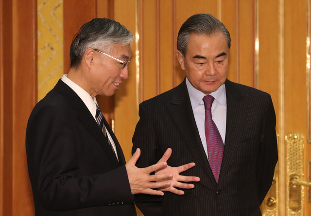 Chinese Foreign Minister and State Councilor Wang Yi speaks with Chinese Ambassador to South Korea Qiu Guohong before meeting with South Korean President Moon Jae-in at the Blue House on Dec. 5.