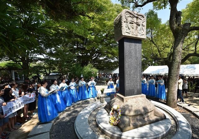 지난 2015년 8월5일 일본 히로시마 평화기념공원 안에 있는 한국인 원폭 피해자 위령비 앞에서 한복을 입은 여성들이 추모곡을 부르고 있다. 연합뉴스