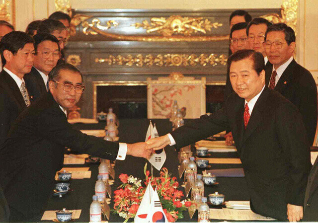 Then-President Kim Dae-jung of South Korea (right) shakes hands with Prime Minister Keizo Obuchi on Oct. 8, 1998, ahead of a summit during which they adopted a joint statement on “partnership towards the 21st century.” (Hankyoreh file photo)