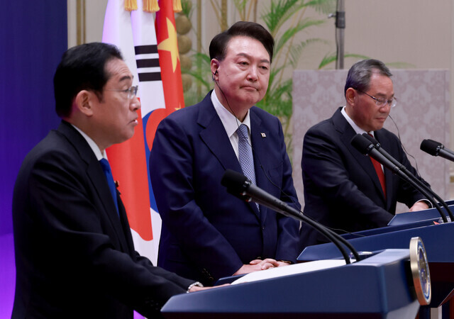 Prime Minister Fumio Kishida of Japan (left) speaks at a joint press conference held after a trilateral summit with South Korean President Yoon Suk-yeol (center) and Chinese Premier Li Qiang (right) at Seoul’s Blue House on May 27, 2024. (Yonhap)