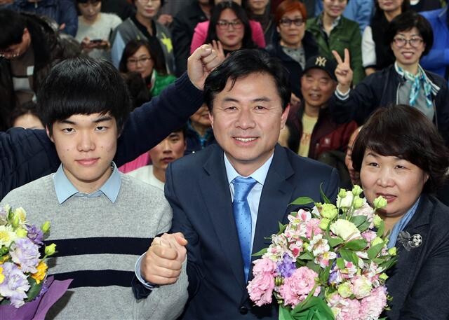 김영춘 당선자가 제20대 총선에서 승리가 확정된 뒤 아들(왼쪽), 아내와 함께 축하를 받고 있다. 연합뉴스