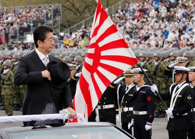 Japanese Prime Minister Shinzo Abe next to the Rising Sun Flag during a Japan Self-Defense Forces exercise in Saitama Prefecture in October 2018. (Reuters/Yonhap News)