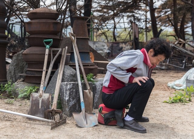 강원도 고성군 토성면 인흥리에 사는 지체장애인 강아무개씨가 4월4일 밤 산불로 불탄 자신의 집 앞에 앉아 있다. 대피 중 넘어져 다쳐서 거동이 더 불편한 상태다.