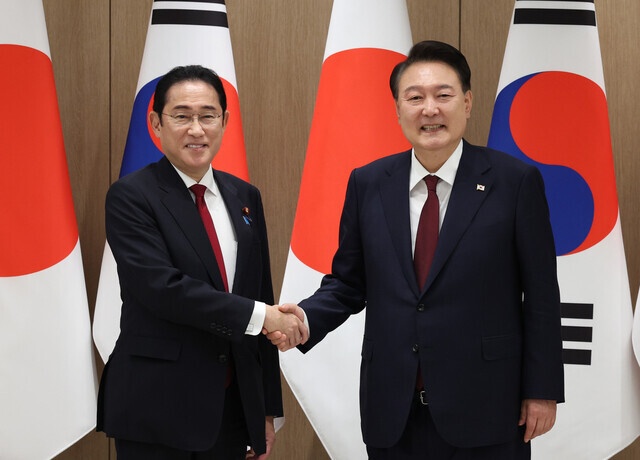 Prime Minister Fumio Kishida of Japan (left) shakes hands with President Yoon Suk-yeol of South Korea ahead of their summit in Seoul on May 26, 2024. (Yonhap)