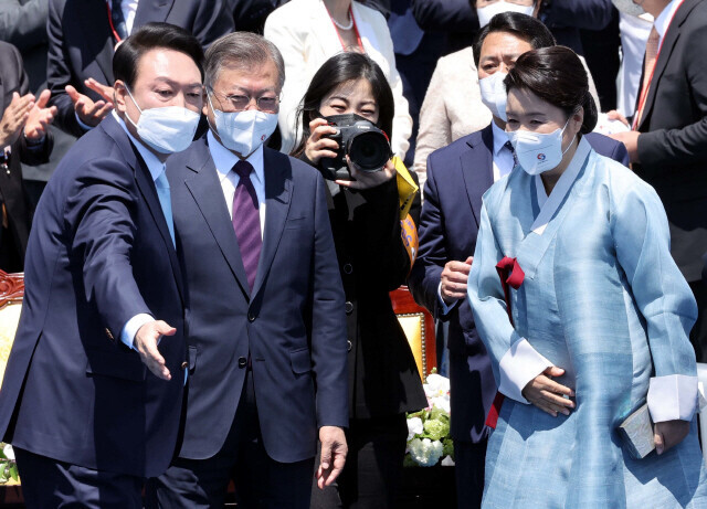 Following Yoon Suk-yeol’s inauguration on May 10, 2022, Yoon guides the departing Moon Jae-in off the stage. (pool photo)