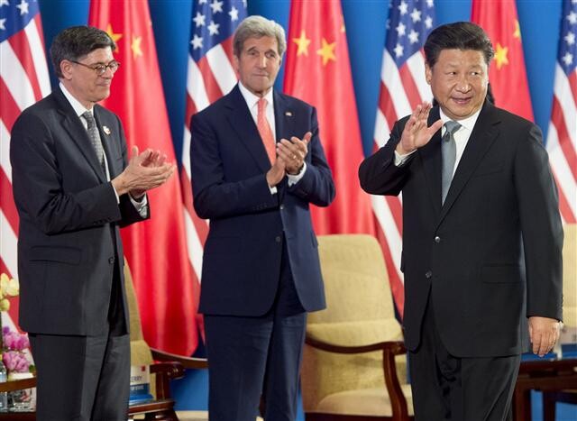 US Secretary of the Treasury Jacob Lew (left) and Secretary of State John Kerry applaud and Chinese President Xi Jinping waves after the two countries’ opening addresses at the eighth Strategic and Economic Dialogue