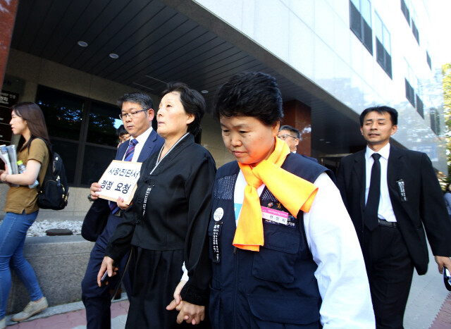 10월4일 고 백남기씨의 부인 박순례씨(가운데)가 ‘병사’로 기재된 사망진단서의 정정을 요청하는 문서를 접수하기 위해 이동하고 있다. 정용일 기자