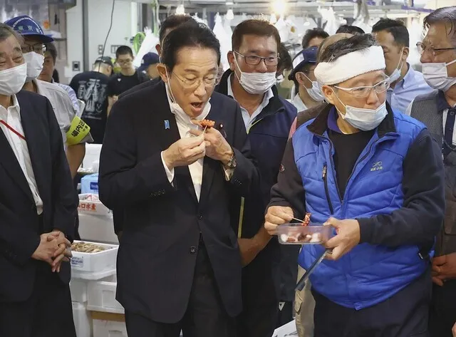 Prime Minister Fumio Kishida of Japan samples octopus during a visit to Toyosu Fish Market in Tokyo on Aug. 31. (Yonhap)