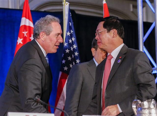 US Trade Representative Micheal Foreman shakes hands with Vietnamese Minister of Industry and Trade Vu Huy Hoang after agreeing to the Trans-Pacific Partnership in Atlanta on Oct. 15