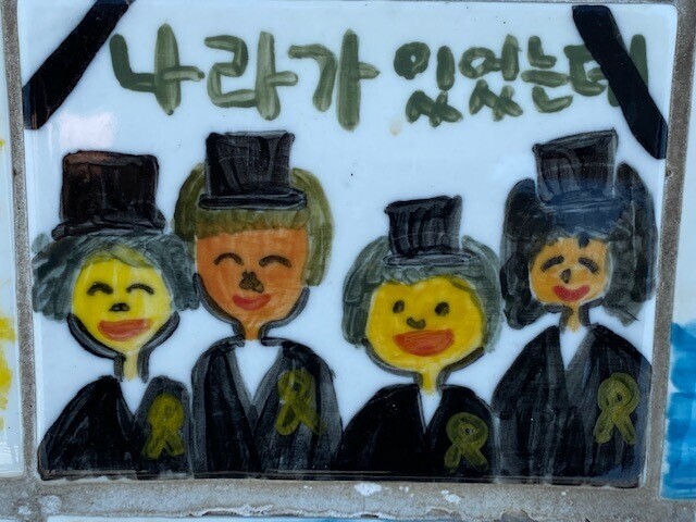 One tile hand-painted by a Korean student featured on a seawall memorial to victims of the Sewol ferry disaster in Jindo’s Paengmok Harbor in South Jeolla Province, reads “The state was there, and yet...” (courtesy of the author)