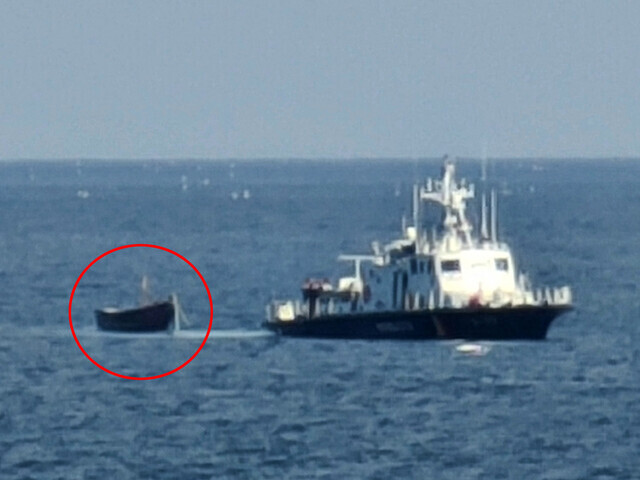 The South Korean military tows a small wooden boat (circled in red) that was discovered by South Korean fishers in the waters near Sokcho after crossing the Northern Limit Line from North Korea on Oct. 24 carrying four North Koreans. (Yonhap)
