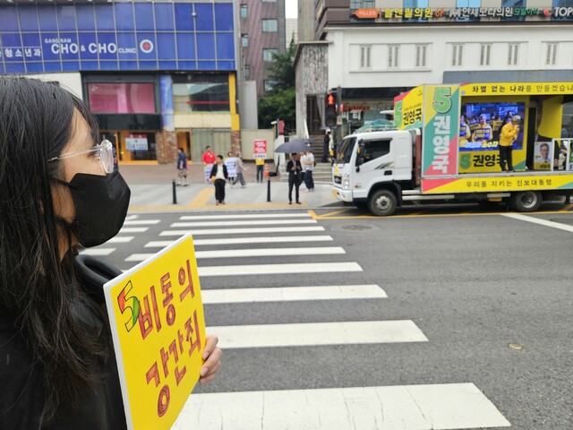 이지연(25·가명)씨가 2025년 6월2일 권영국 당시 민주노동당 대선 후보의 서울 강남역 유세 현장에서 ‘비동의강간죄'라고 적힌 손팻말을 들고 서 있다. 류석우 기자