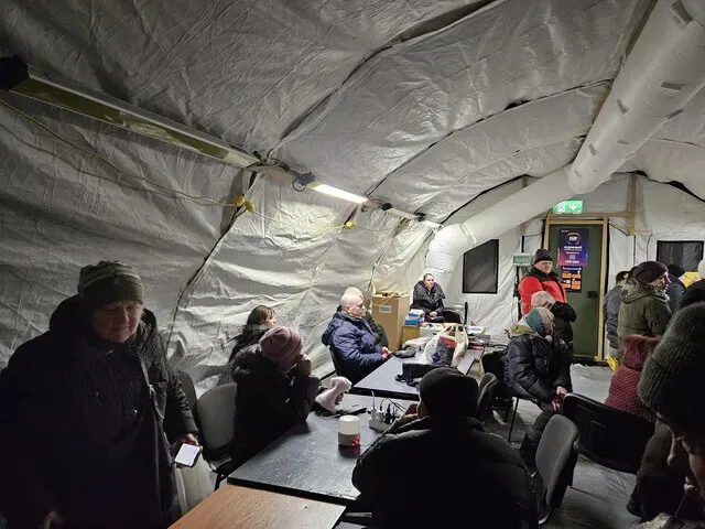 Tenants in an apartment in Kyiv, Ukraine, take shelter in a tent on Feb. 7, 2026, after a power outage due to drone strikes. (Cheon Ho-sung/Hankyoreh)
