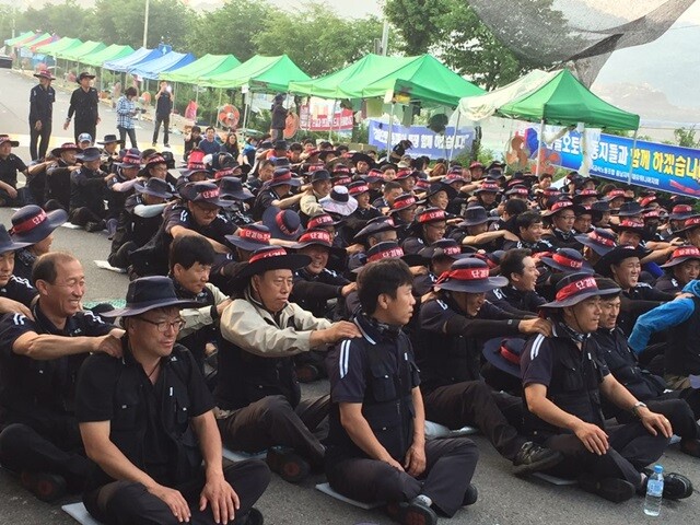 8월4일 새벽 6시 공장 정문 앞에 모인 조합원들이 기상집회를 하며 동료들의 어깨를 주무르고 있다. 박점규 제공