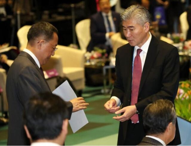 US Ambassador to the Philippines Sung Kim conveys a document envelope to North Korean Foreign Minister Ri Yong-ho ahead of the ASEAN Regional Forum (ARF) foreign ministers meeting. (Yonhap News)