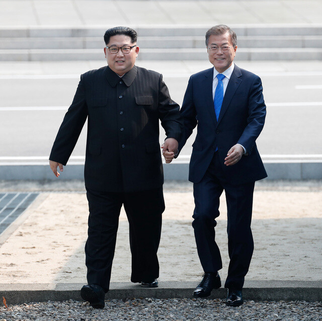 South Korean President Moon Jae-in (right) and North Korean leader Kim Jong-un cross the Military Demarcation Line (MDL) together ahead of the Inter-Korean Summit in Panmunjeom on Apr. 27. (Blue House photo pool)
