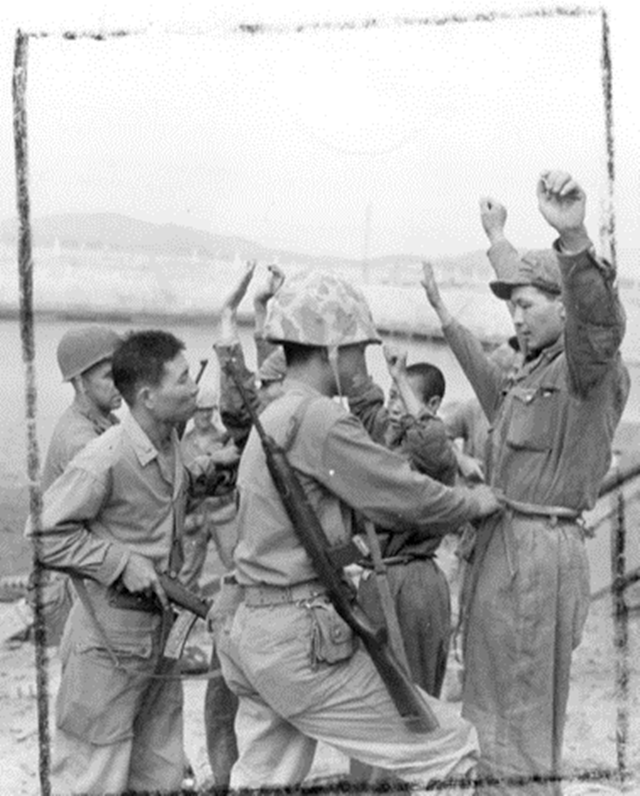 &#10102;미군 상륙부대가 인천상륙작전 동안 포로로 잡은 적 병사들을 검사하고 있다. 1950년 9월15일 로버트 촬영.