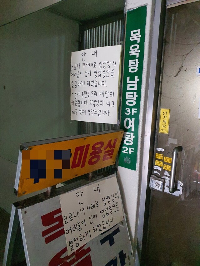 지난 25일 오후 광주광역시 북구 한 목욕탕 계산대 앞에 코로나19로 문을 닫는다는 안내문이 붙어 있다. 정대하 기자