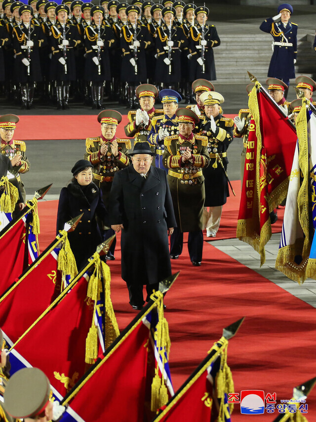 North Korean leader Kim Jong-un appears at the nighttime military parade in Pyongyang’s Kim Il-sung Square held for the 75th founding anniversary of the Korean People’s Army on Feb. 8 hand in hand with his daughter Kim Ju-ae. (KCNA/Yonhap)