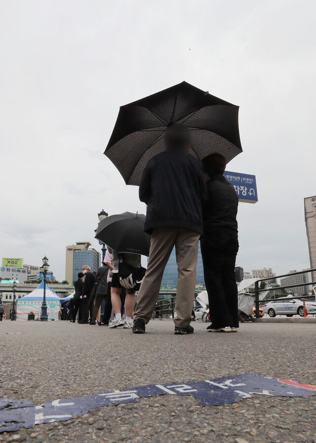 20일 오전 서울역광장에 마련된 임시선별진료소에서 시민들이 코로나19 검사를 받기 위해 줄을 서 있다. 연합뉴스