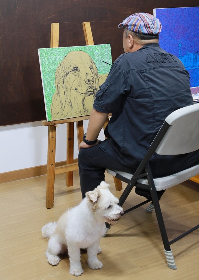 김 화백이 작업실에서 애완견을 그리고 있다.