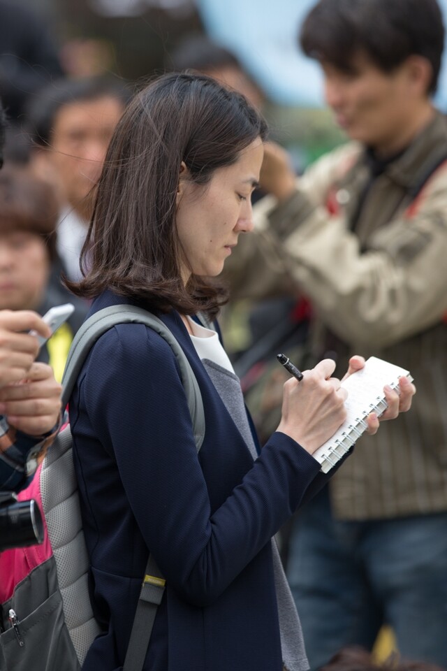 세월호 참사 관련 집회에서 기자가 취재 내용을 적고 있다.