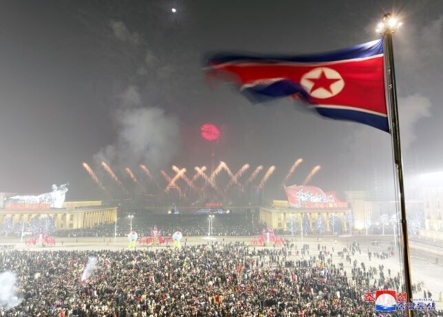 People fill Kim Il-sung Square in Pyongyang and fireworks light up the sky at the stroke of midnight on New Year’s Eve. (KCNA/Yonhap)