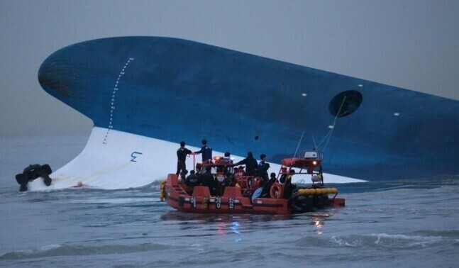 A rescue boat carrying Korean Coast Guard members circles near the bow of the Sewol ferry as it sinks in the water off Donggeocha Island in Jindo, South Jeolla Province, on the afternoon of Apr. 16, 2014. (Kim Bong-gyu)