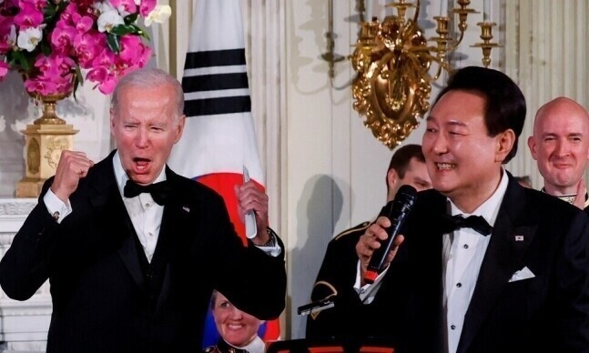 President Yoon Suk-yeol (right) sings “American Pie” at a state dinner hosted in his honor at the White House in April 2023, as US President Joe Biden cheers him on. (Yonhap) 