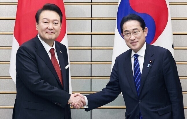 President Yoon Suk-yeol of Korea (left) shakes hands with Japanese Prime Minister Fumio Kishida ahead of their summit in March 2023. (Yonhap)