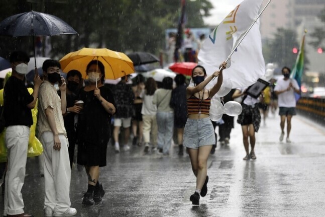 Participants in the Seoul Queer Parade march down the streets of downtown Seoul on July 16 amid heavy rainfall. (Kim Myoung-jin/The Hankyoreh)
