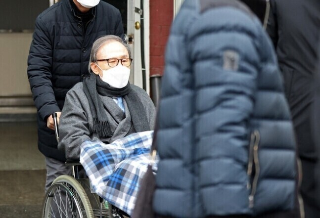 Former President Lee Myung-bak is wheeled out of Seoul National University Hospital in central Seoul on Feb. 10, 2021, for 50 days of treatment for existing conditions. (Yonhap)