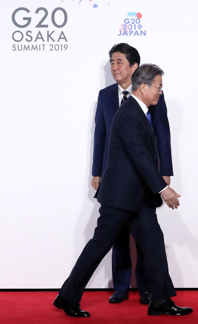 South Korean President Moon Jae-in moves along after shaking hands with Japanese Prime Minister Shinzo Abe during the G20 Osaka summit on June 28.