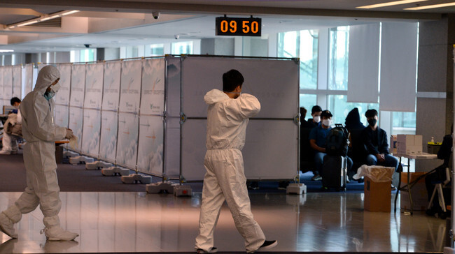 Quarantine workers question and test travelers arriving from overseas at Incheon International Airport on Mar. 23. (photo pool)
