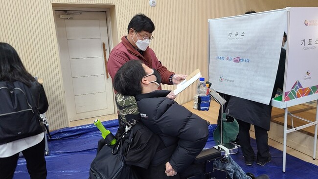 4일 오전 11시30분께 서울 종로구 청운효자동 사전투표소에서 투표를 기다리고 있는 뇌병변 1급 장애인 박지호(43)씨와 투표보조인 김인호(61)씨. 박지영 기자