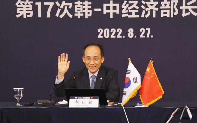 Deputy Prime Minister and Minister of Economy and Finance Choo Kyung-ho waves to his Chinese counterpart, He Lifeng, minister of the National Development and Reform Commission, during a virtual meeting between the two on Aug. 27. (courtesy MOEF)