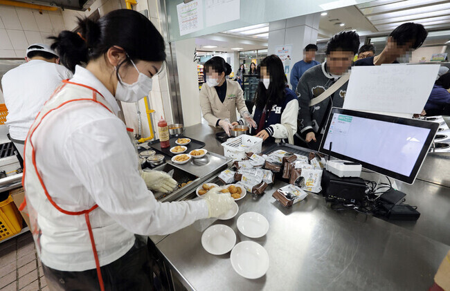 Students collect their lunch trays at a cafeteria at Kyung Hee University in Seoul’s Dongdaemun District in March 2023. (Yonhap)