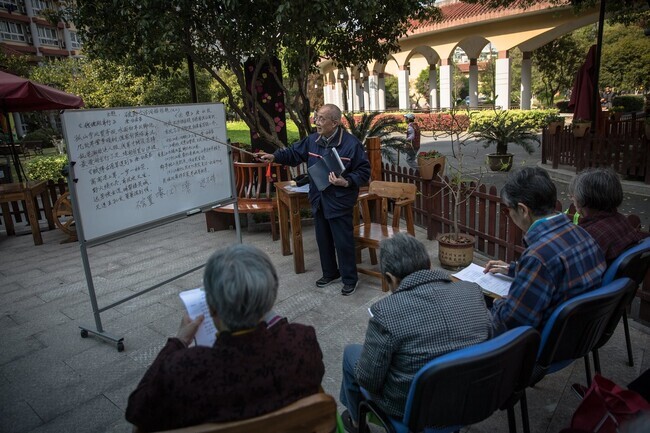 A middle school instructor teaches Chinese poetry to seniors at a social welfare center in Hangzhou, China. (EPA/Yonhap News)
