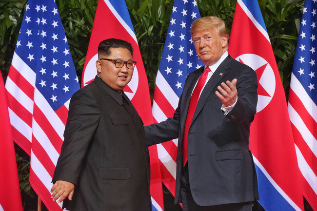 김정은 북한 국무위원장과 도널드 트럼프 미국 대통령이 지난 2018년 6월12일(현지시각) 싱가포르 카펠라호텔에서 만나 악수한 뒤 사진 촬영을 위해 취재진을 잠시 바로 보고 있다. 케빈 림/스트레이츠 타임스 제공