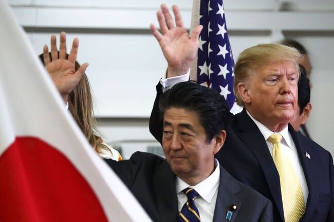 US President Donald Trump and Japanese Prime Minister Shinzo Abe wave after delivering a speech to Japanese and US troops as they board Japan Maritime Self-Defense Force‘s helicopter carrier DDH-184 Kaga in Yokosuka