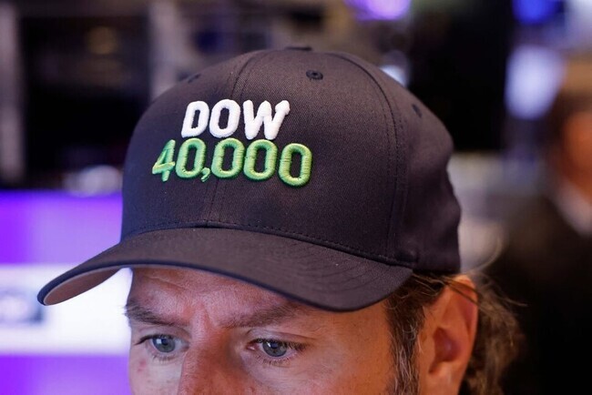 A trader on the floor of the New York Stock Exchange wears a hat to mark the first time the Dow closed above 40,000. (AFP/Yonhap)