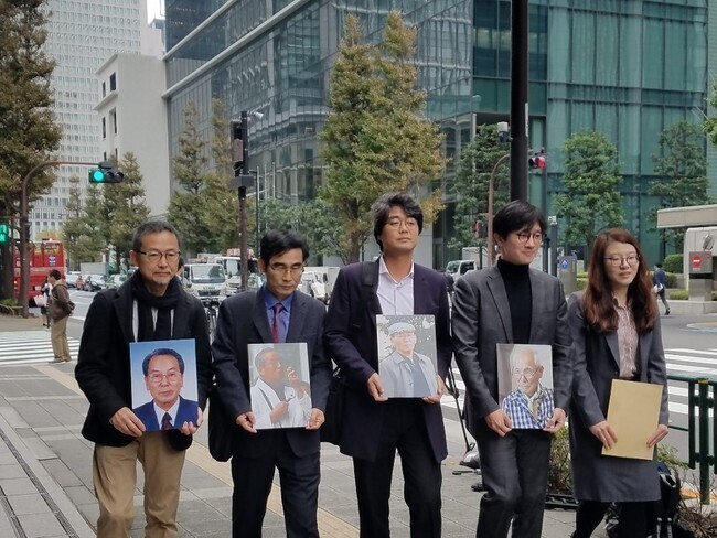 Korean and Japanese activists and legal representatives of plaintiffs in the forced labor case carry portraits of four of the victims of Japan’s forced labor as well as a request that the Supreme Court’s ruling be carried out to the headquarters of Nippon Steel in Tokyo on Nov. 12, 2018. (Hankyoreh file photo)