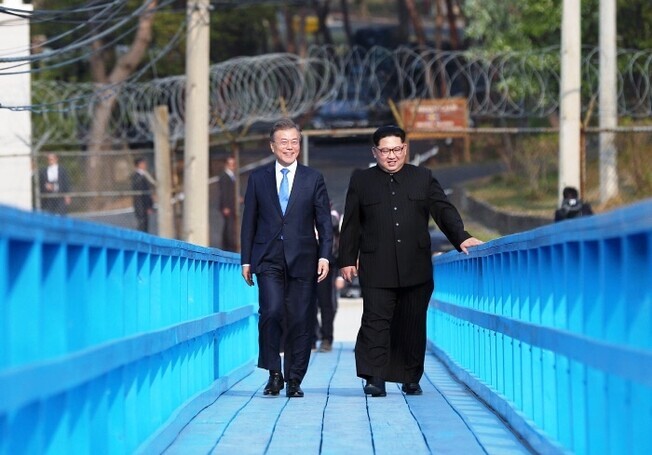 South Korean President Moon Jae-in and North Korean leader Kim Jong-un walk across a pedestrian bridge in Panmunjom on Apr. 27, 2018. (photo pool)