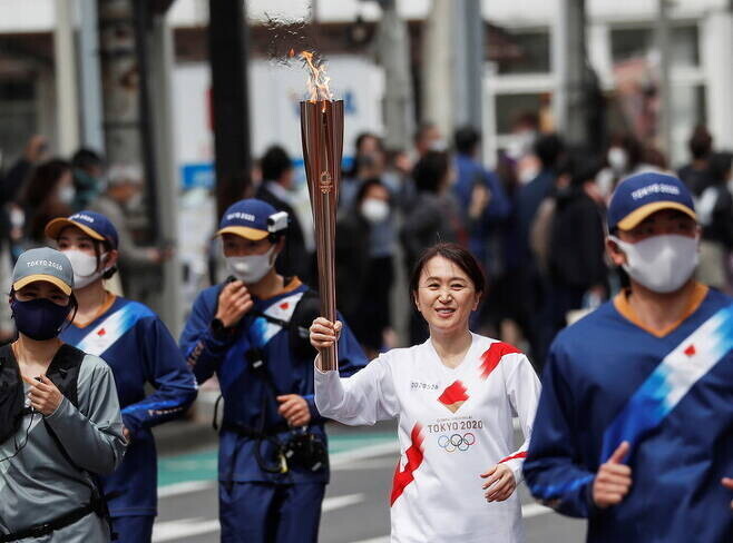 Torchbearer Junko Ito runs during the Tokyo 2020 Olympic torch relay on the second day of the relay in Fukushima, Japan on March 26. (Reuters/Yonhap News)