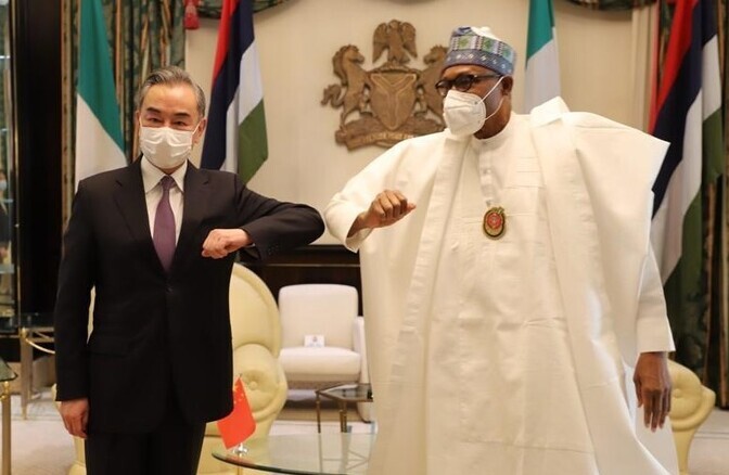 Chinese Foreign Minister Wang Yi poses for a photo with Muhammadu Buhari, the president of Nigeria, during a meeting in January 2021. (Xinhua/Yonhap News)
