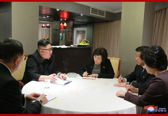In this photo provided by the Korean Central News Agency, North Korean leader Kim Jong Un receives reports on the meetings between US and North Korea special envoys ahead of the second summit between Kim and then-US President Donald Trump at the Melia Hotel in Hanoi, Vietnam. The woman reporting to Kim in the center is North Korean First Vice Foreign Minister Choe Son-hui. (Yonhap News)