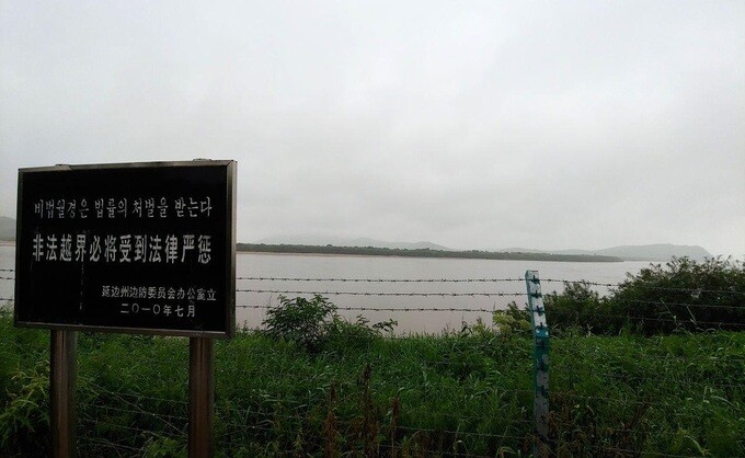 A photograph taken of a sign on the China-North Korea border