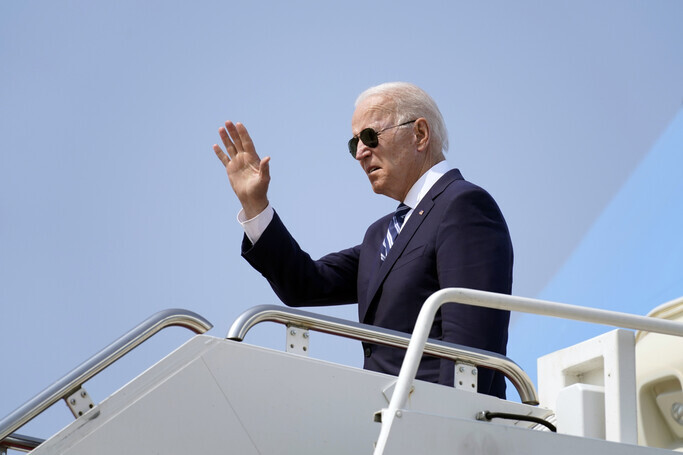 US President Joe Biden waves his hand as he boards Air Force One at Quonset State Airport in North Kingstown, Rhode Island, on Wednesday. (AP/Yonhap News)